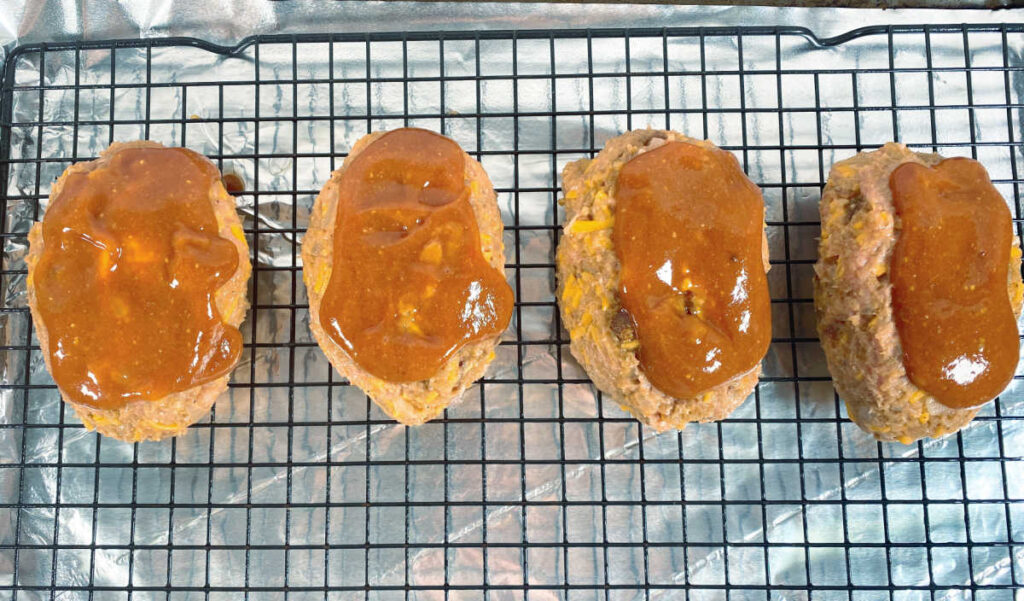 Process photo - meatloaves are glazed and on the baking sheet waiting to be cooked. 