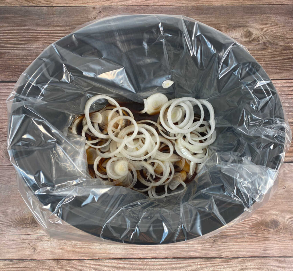 Process shot - onions and other ingredients sit in a slow cooker. 