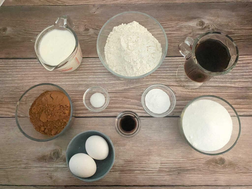 ingredients for the recipe sit in glass bowls on a wooden background. 