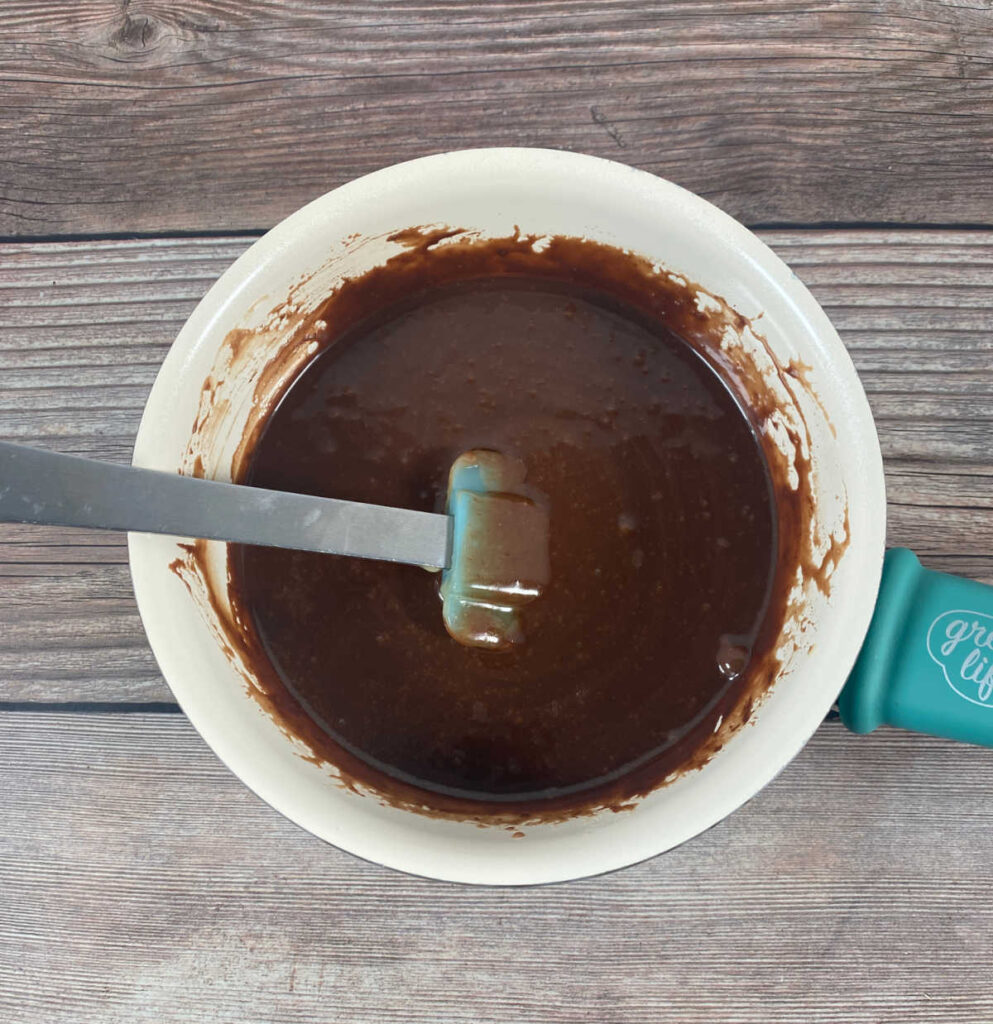 Process shot - glaze ingredients in a saucepan on a wooden background