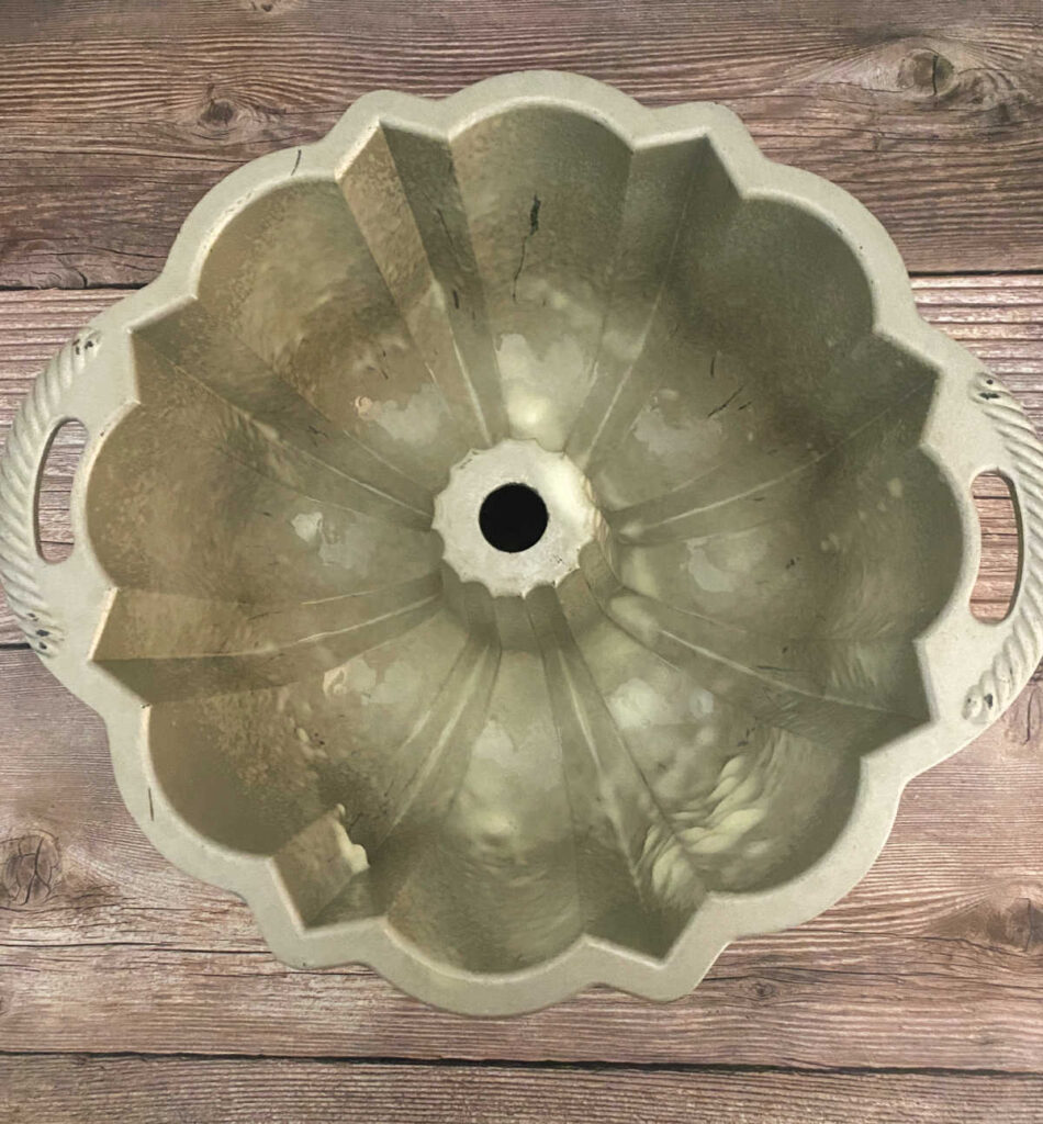 process shot - greased bundt pan sits on a wooden background. 