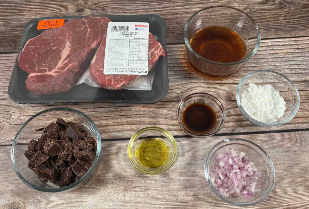 Ingredients for the recipe sit on a wooden background. 