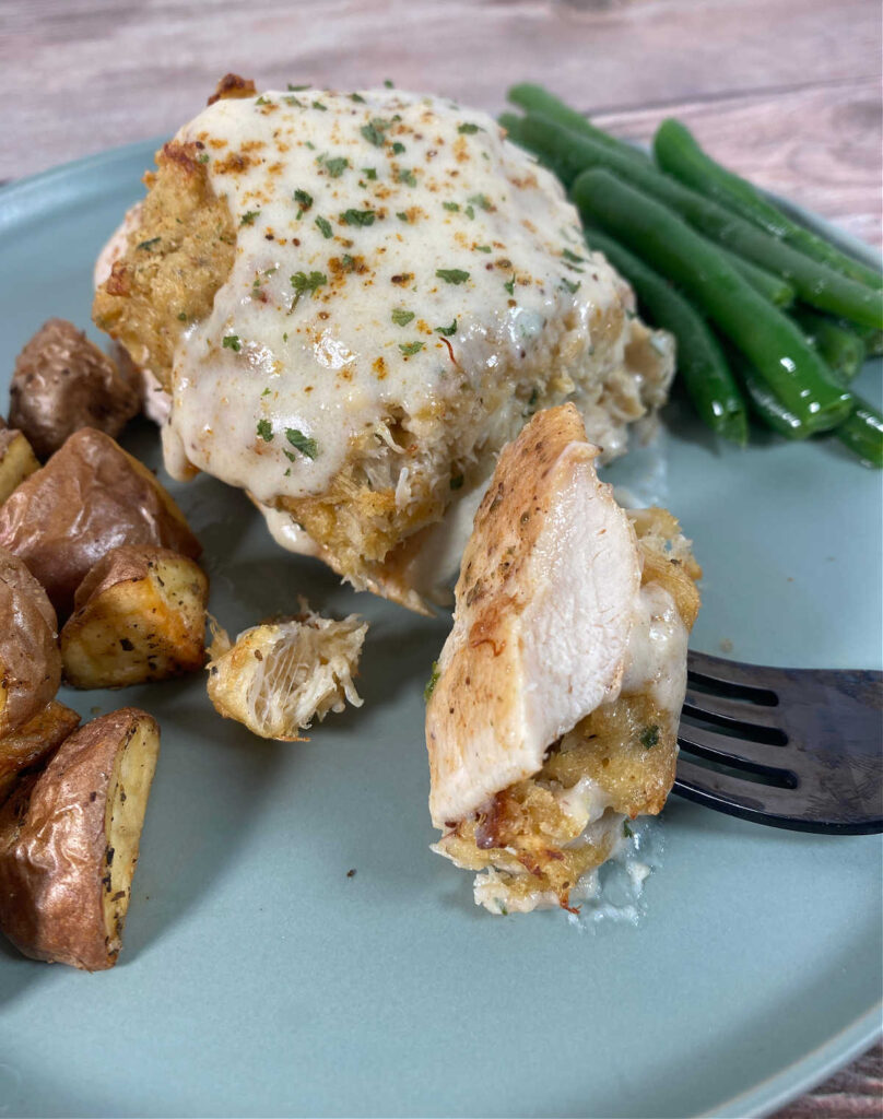 Close up image of recipe with bite of chicken and crab on a fork. 