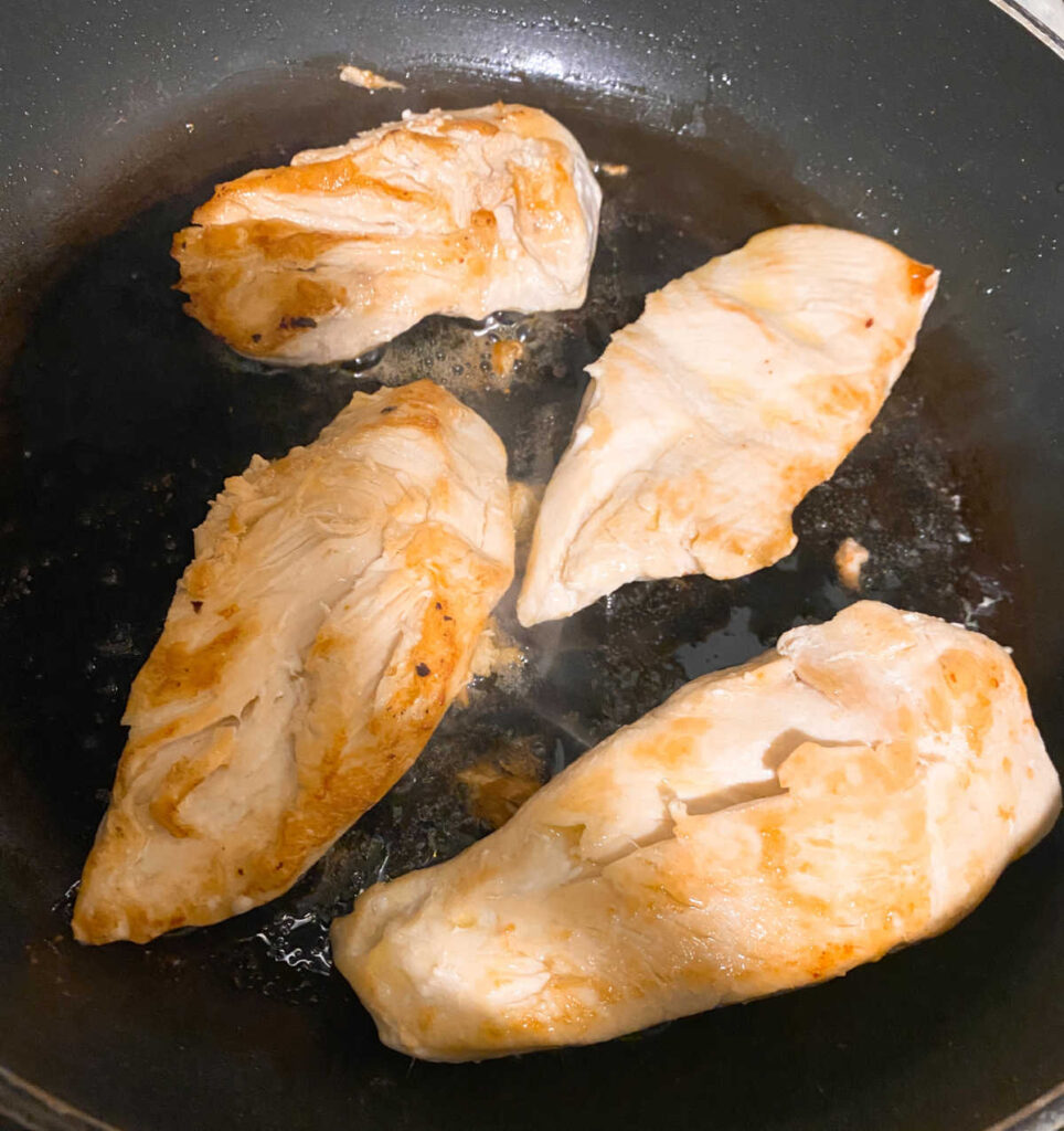 Process shot - chicken cooking in a skillet. 