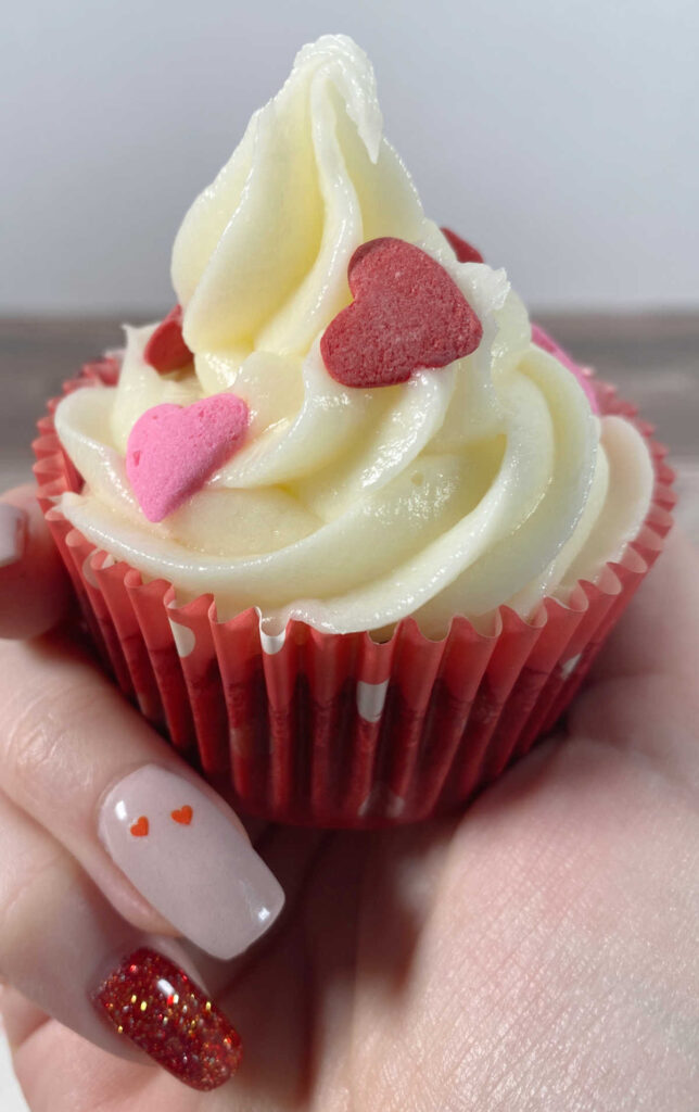 close up of cupcake decorated with heart sprinkles 