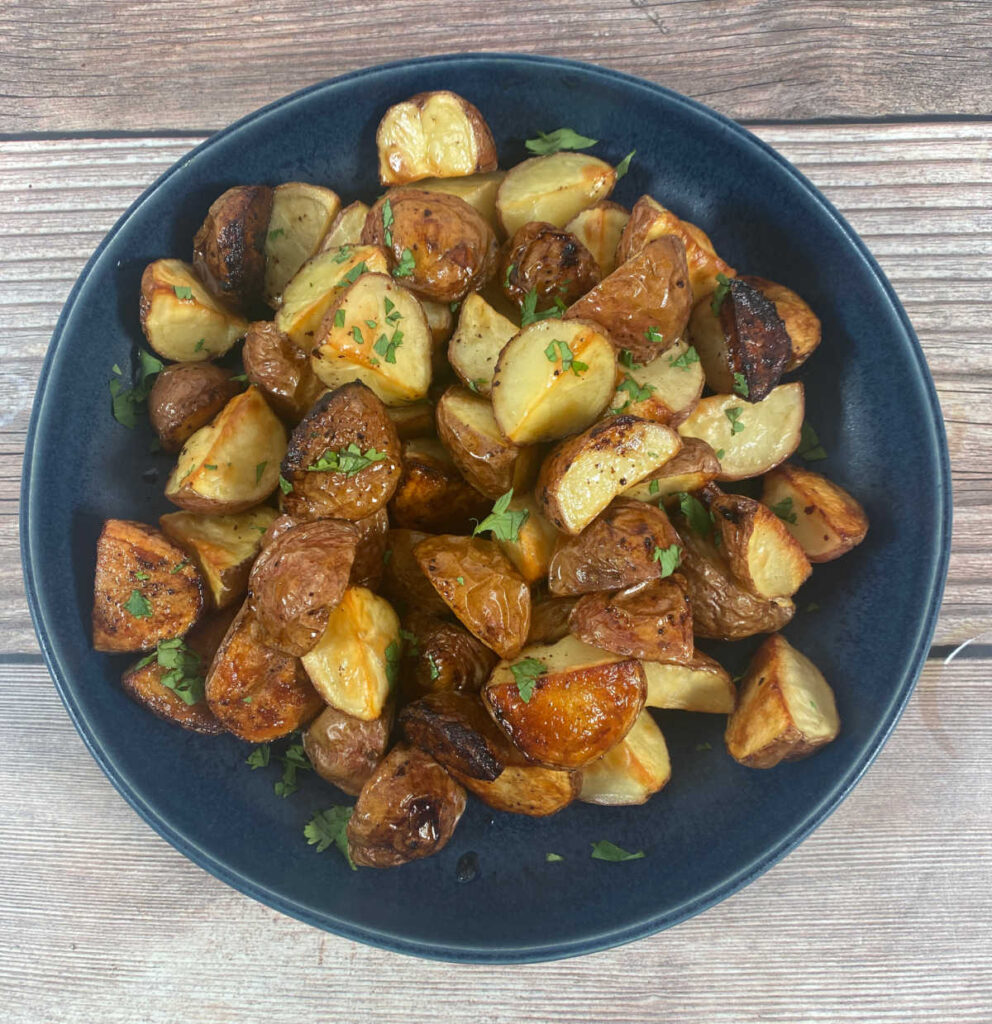 Close up overhead image of potatoes in a navy blue bowl. 