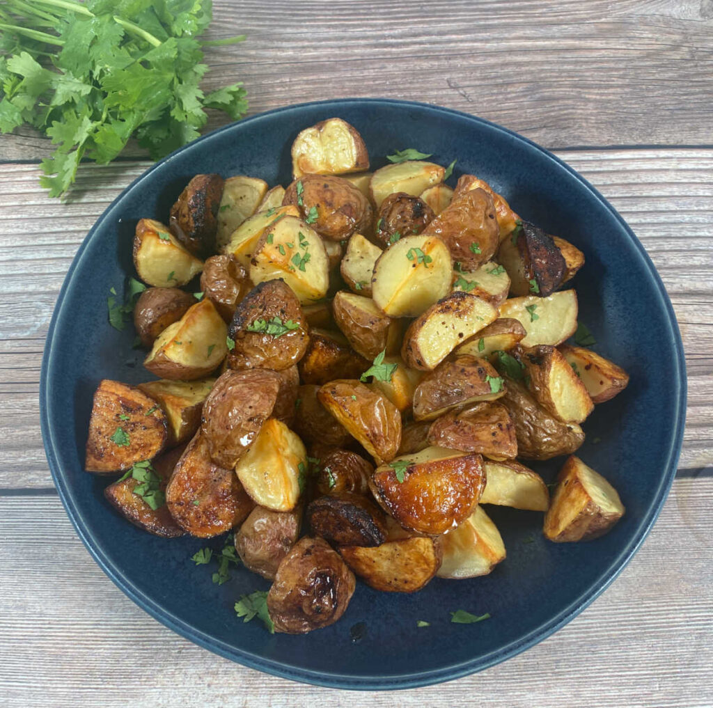 Overhead view of potatoes piled up in a navy blue bowl. 