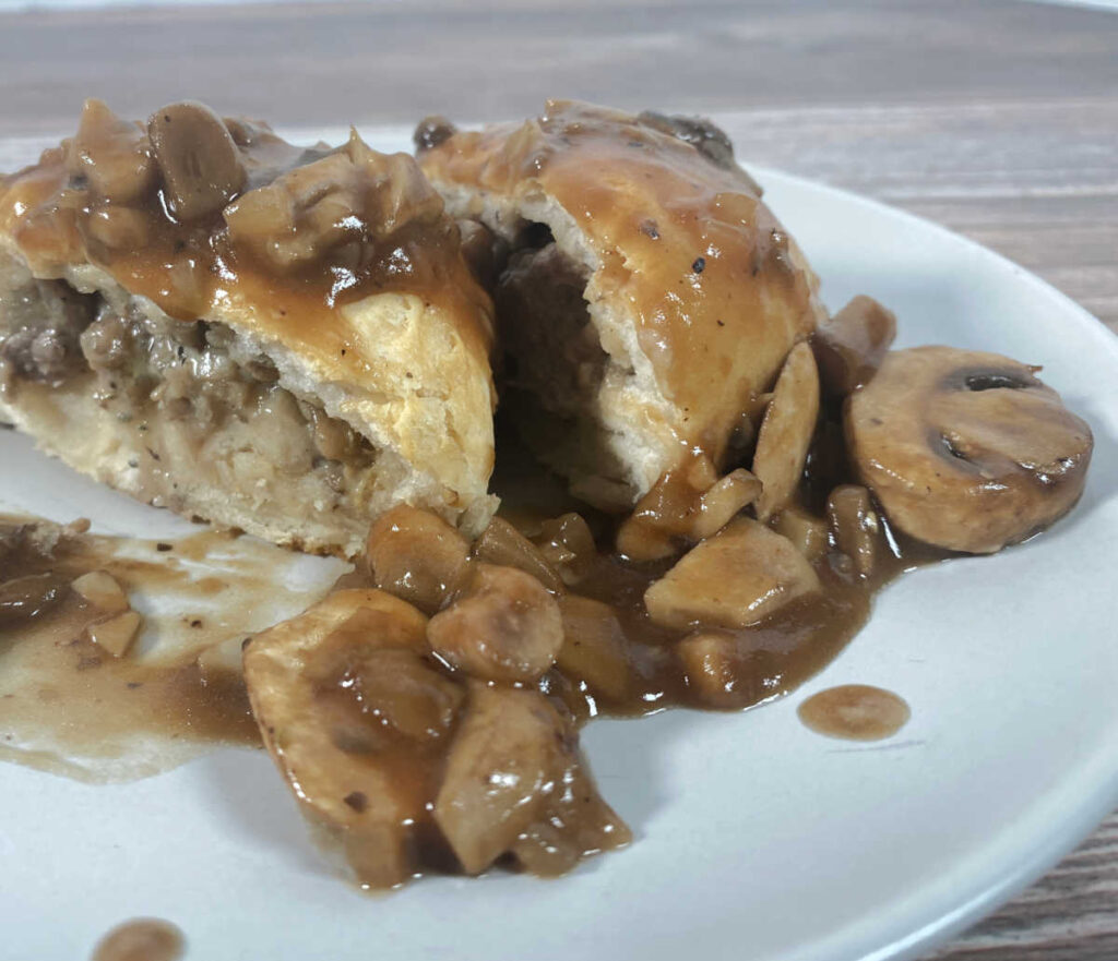 biscuit cut in half to show the inside, topped with mushroom sauce.