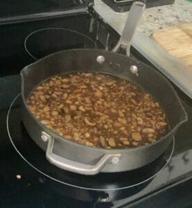 process shot - mushroom sauce cooking in a pan on the stove. 