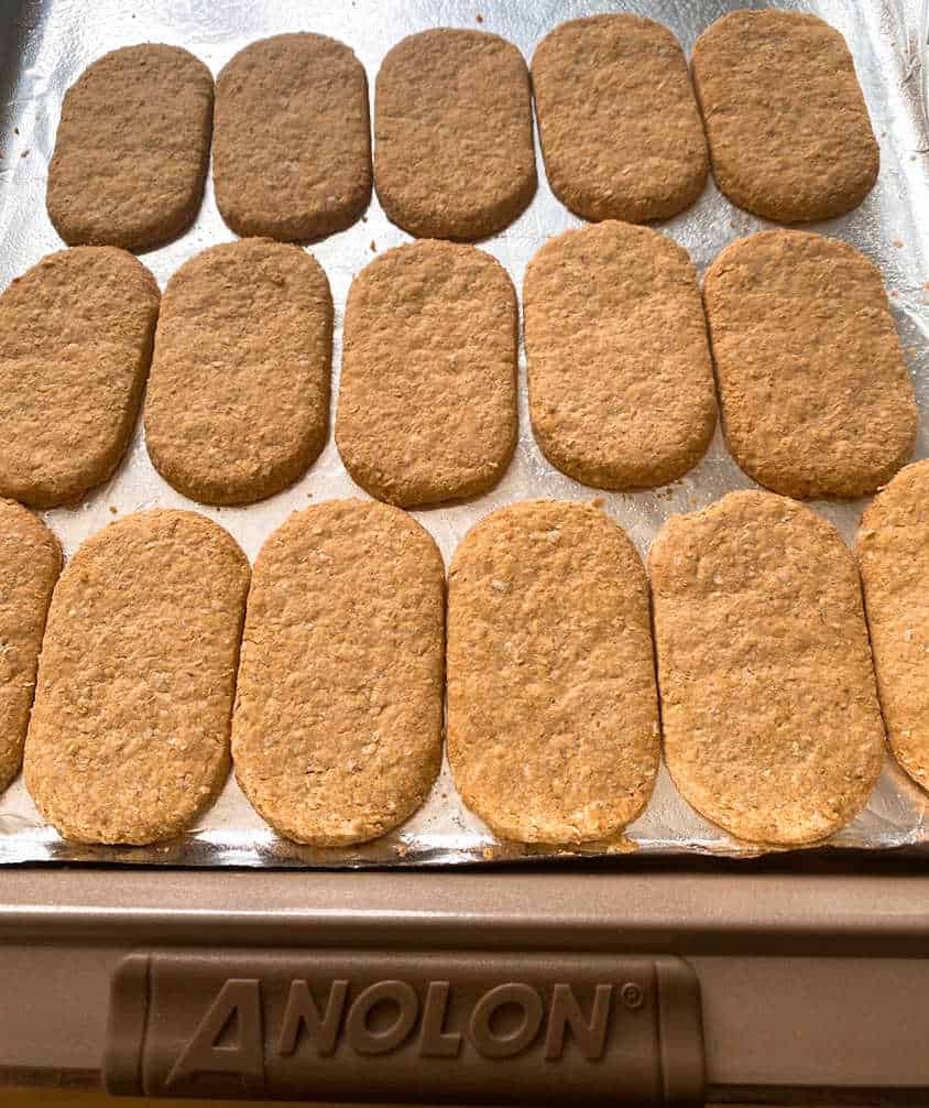 Process shot - graham crackers layered on a baking sheet lined with foil. 