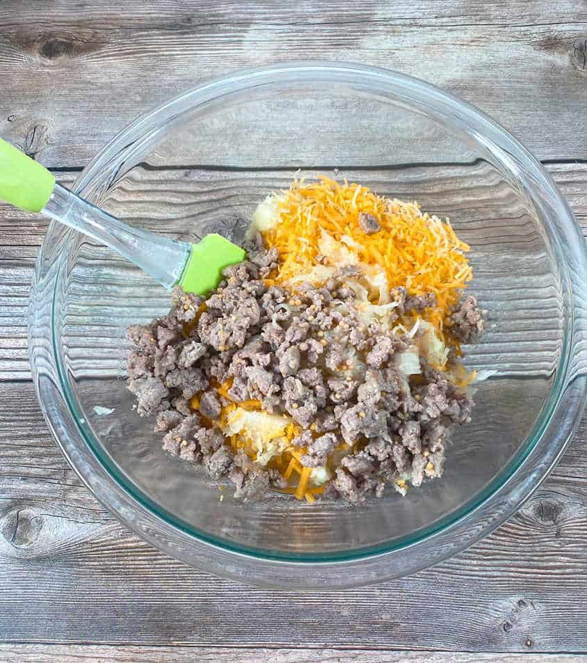 Process shot - filling ingredients sits in a glass bowl on a wooden background. 