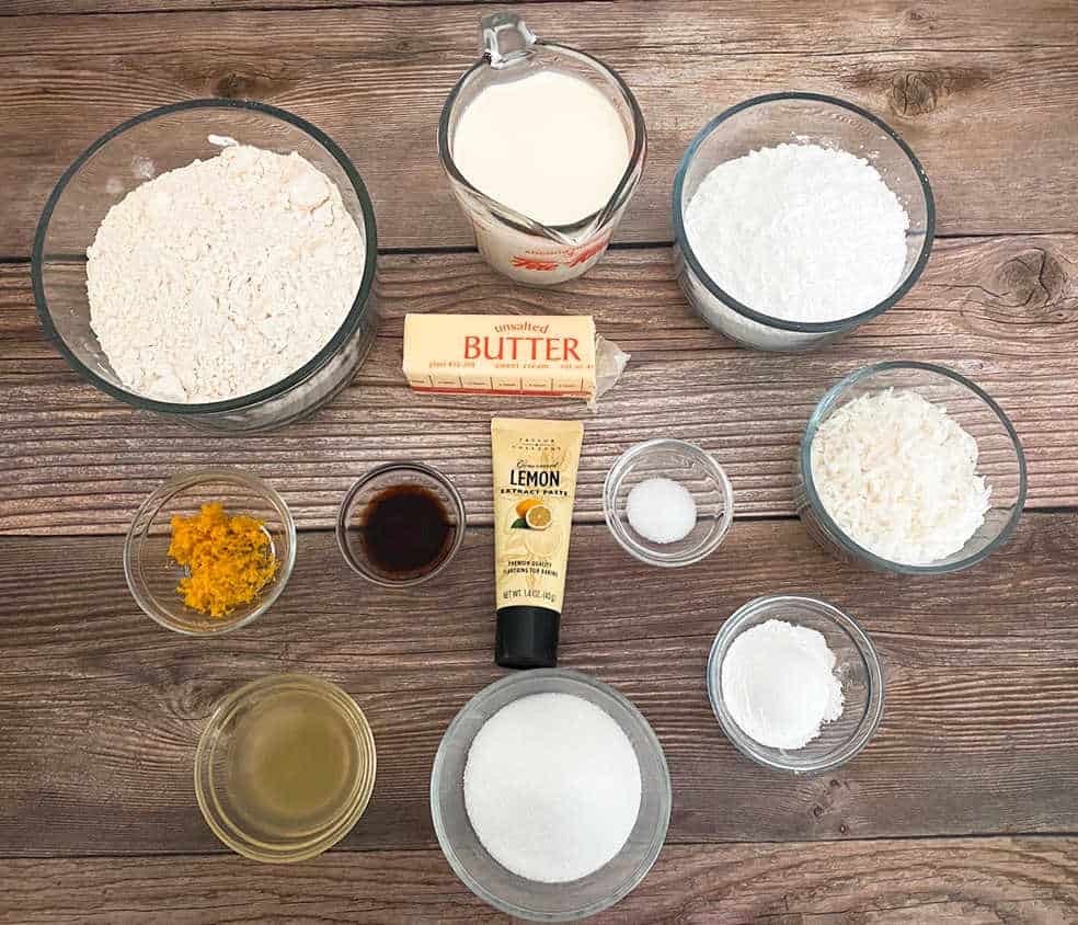 ingredients for the recipe are portioned out in glass dishes, sitting on a wooden background. 