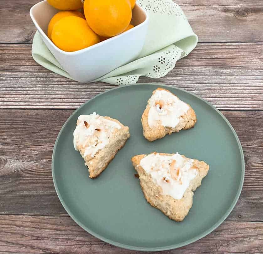 Scones sitting on a light green plate on a wooden background. 