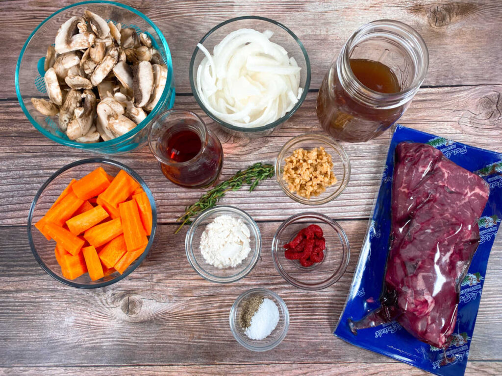 Ingredients for the recipe are portioned out in glass bowls sitting on a wooden background. 