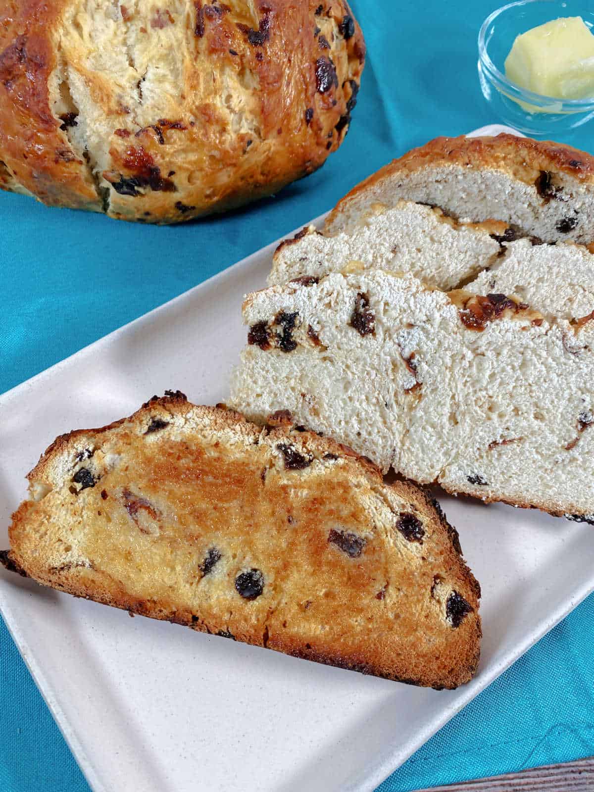 Slices of bread, one toasted sit on a rectangle platter. 