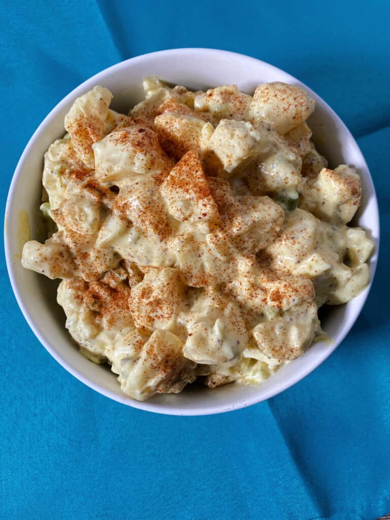 overhead image of potato salad in a white bowl. 