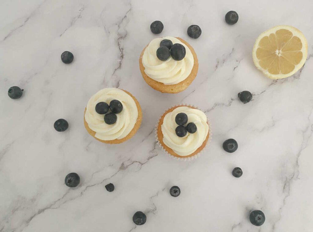 Cupcakes sit on a marble background. 