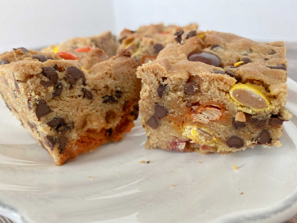 Close up image of cookie bars on a white scalloped plate. 