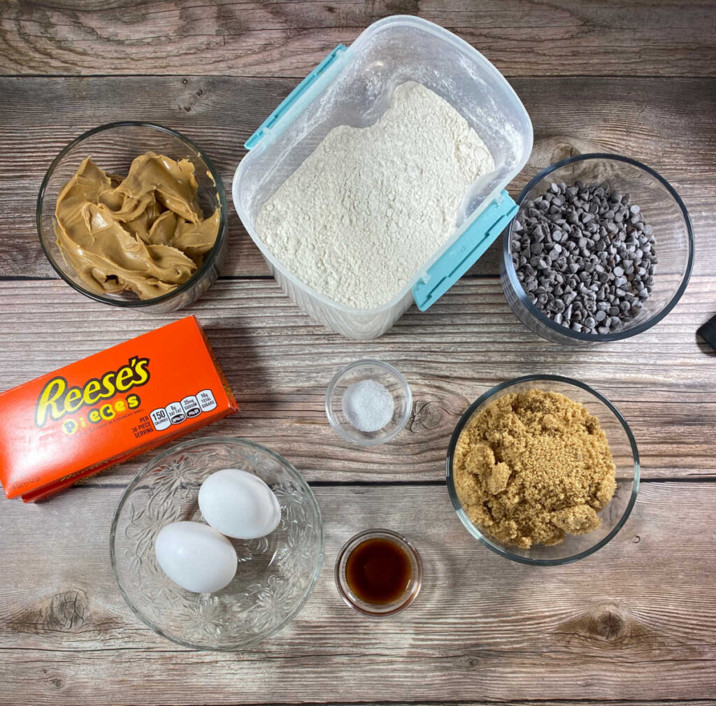 Ingredients sit on a wooden background in glass bowls. 