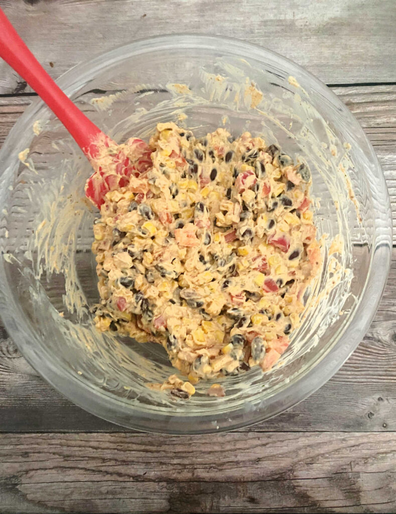 Process shot - mixed ingredients in a bowl with a red spatula.