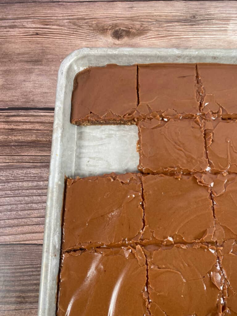 Cake, cut into squares in the jelly roll pan with one piece missing. 