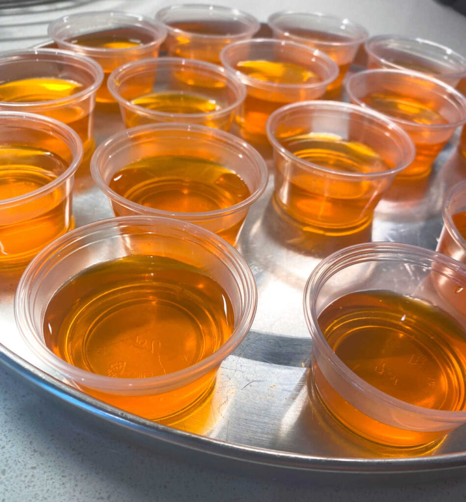 jello shots sit on a metal pan.