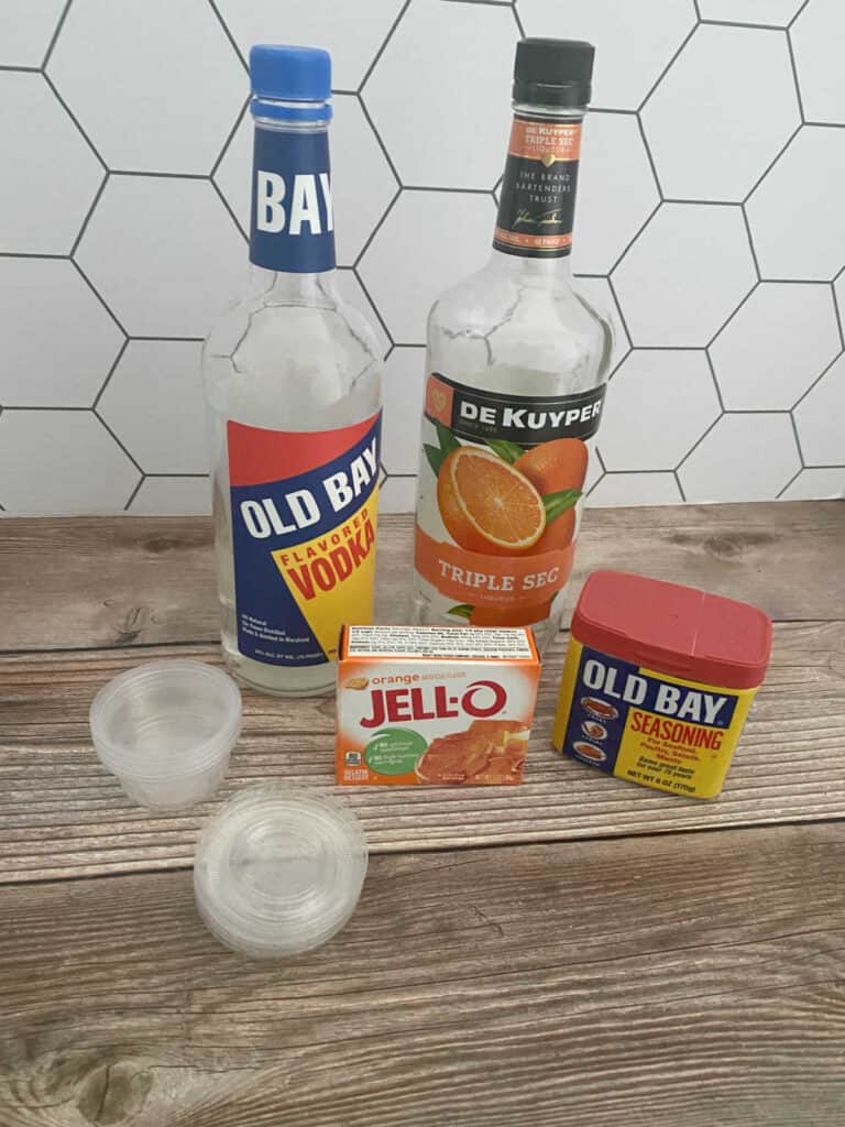 ingredients for the jello shooters sit on a wooden background.