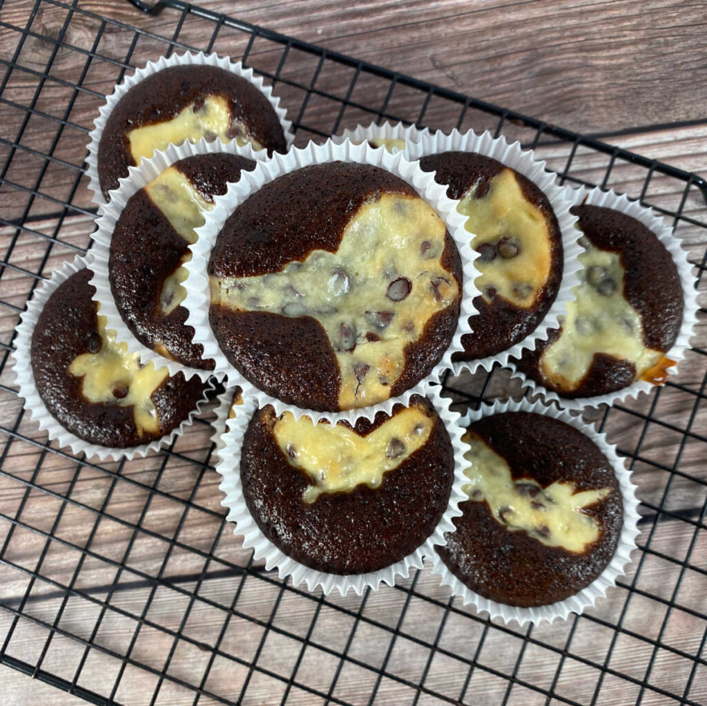 overhead image of cupcakes stacked on a wire cooling rack.