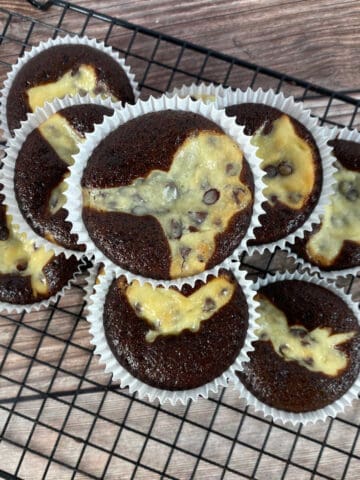 overhead image of cupcakes stacked on a wire cooling rack.