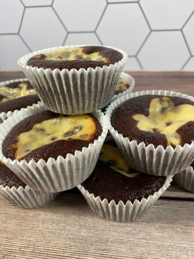 stacked cupcakes sit on a wooden background. 