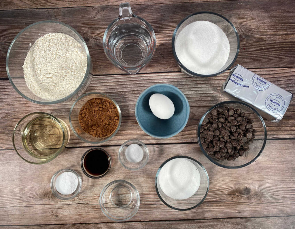 ingredients sit in glass bowls on a wooden background. 