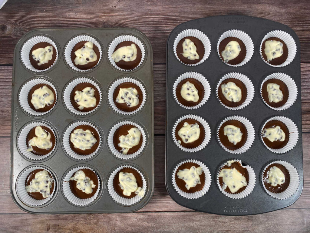 Process shot - cupcakes dolloped with cream cheese filling ready to be baked. 
