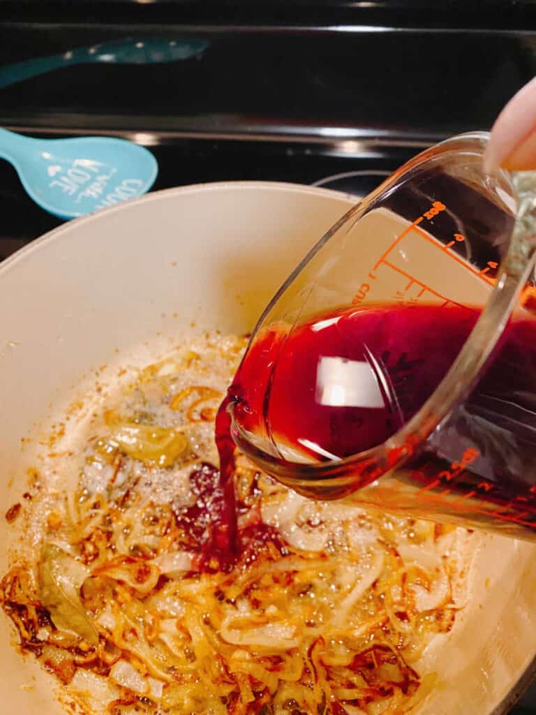 Process shot - wine being poured into onion mixture. 