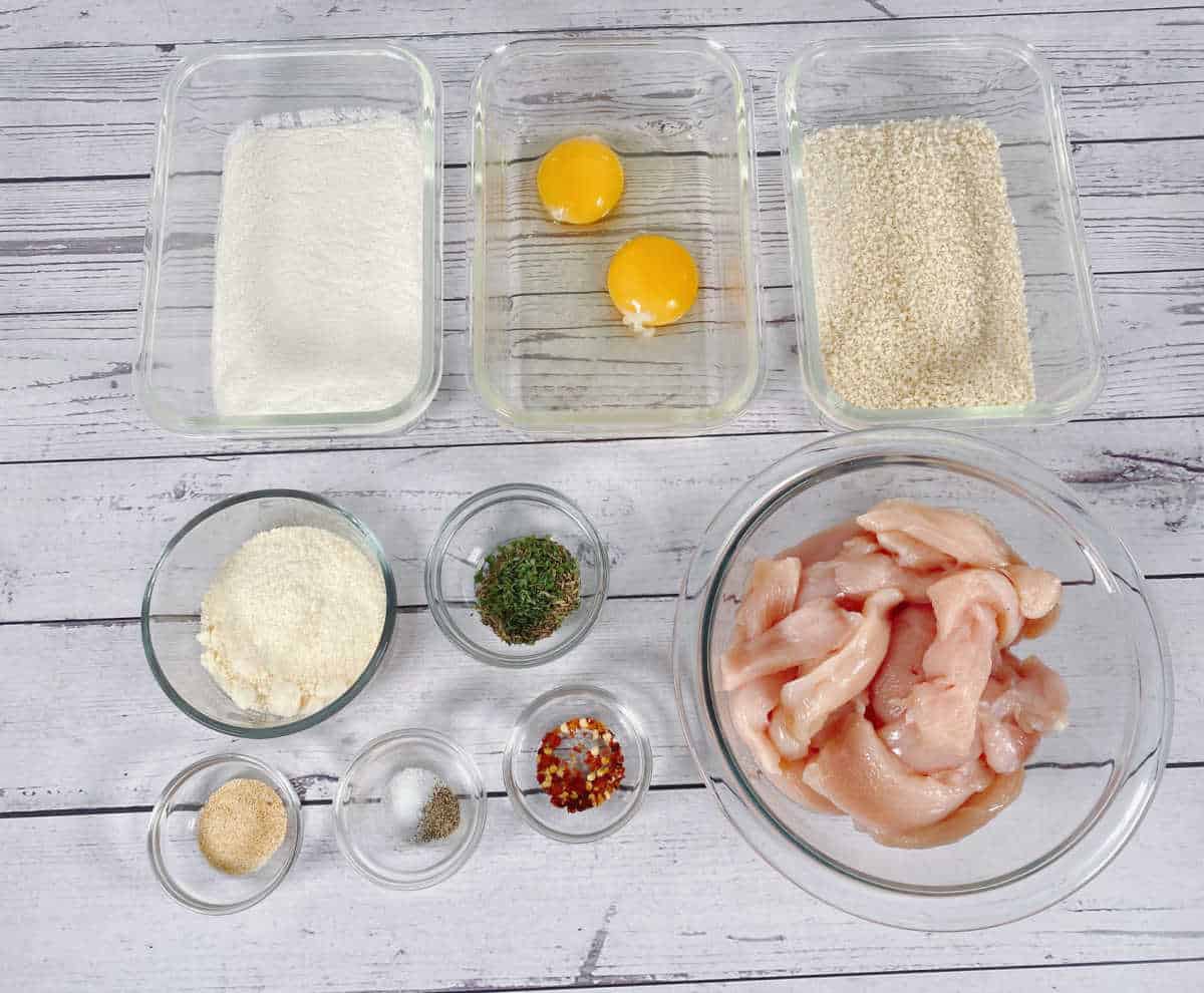 Ingredients sit in glass bowls and dishes on a white wooden background. 