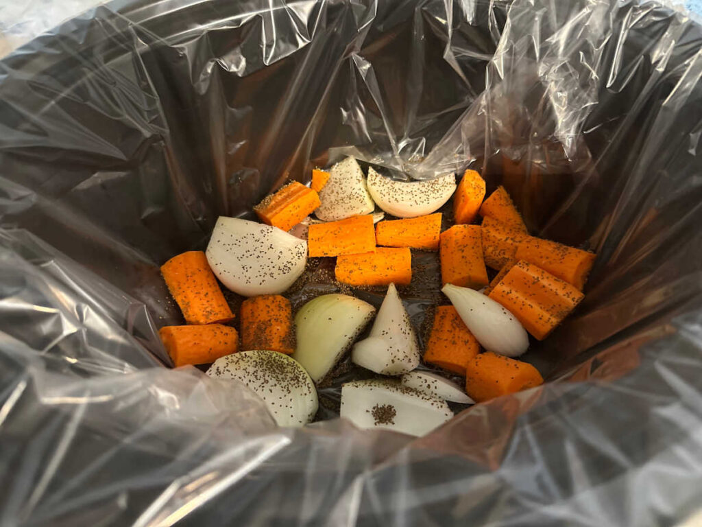 Process shot - seasoned vegetables in a crock pot with a liner. 