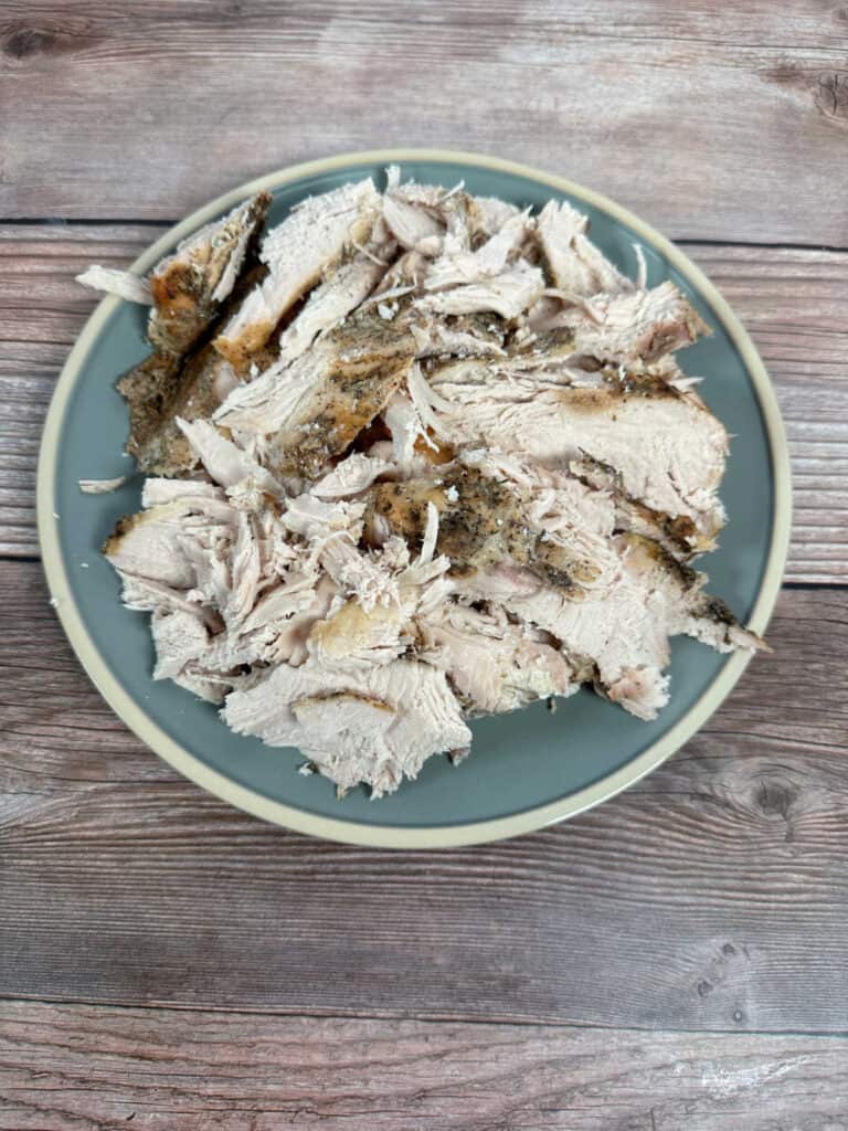 Sliced turkey breast on a blue round plate.