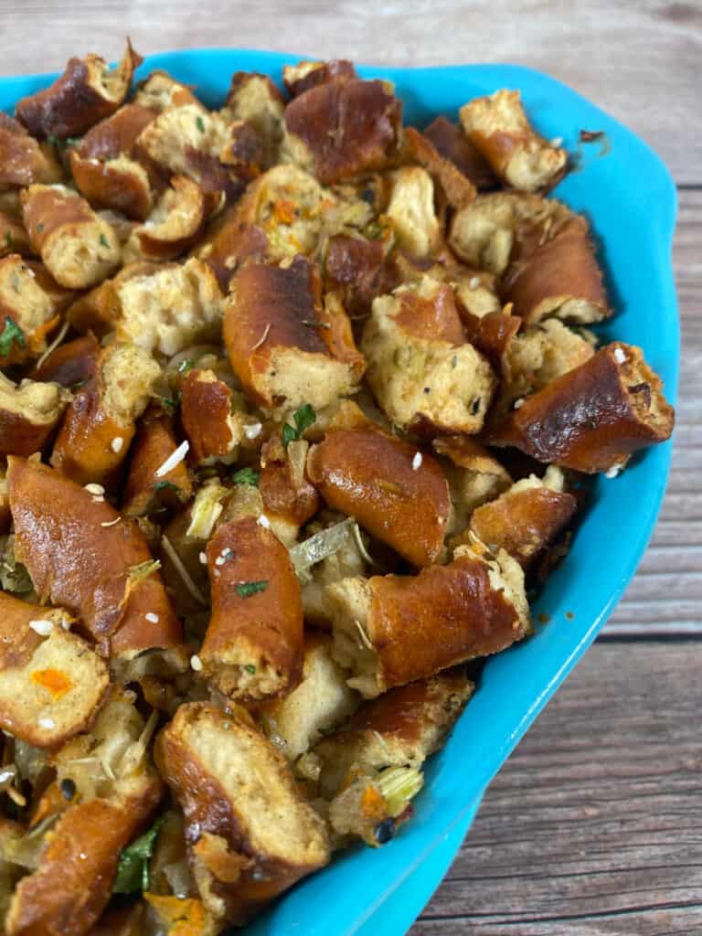 Close up, angled image of stuffing in a bright blue casserole dish.