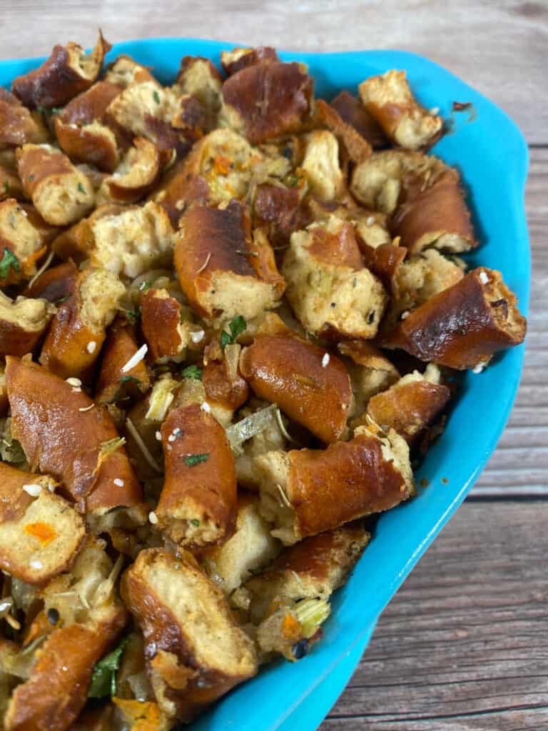 Close up, angled image of stuffing in a bright blue casserole dish. 