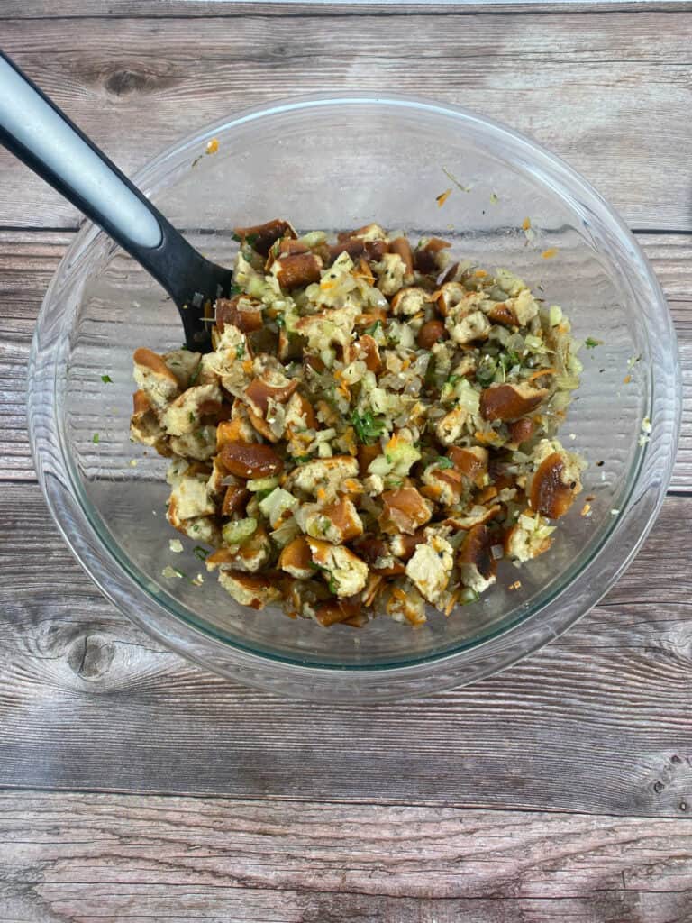 Process shot- cooked vegetables and baked pretzel pieces mixed together in a bowl. 