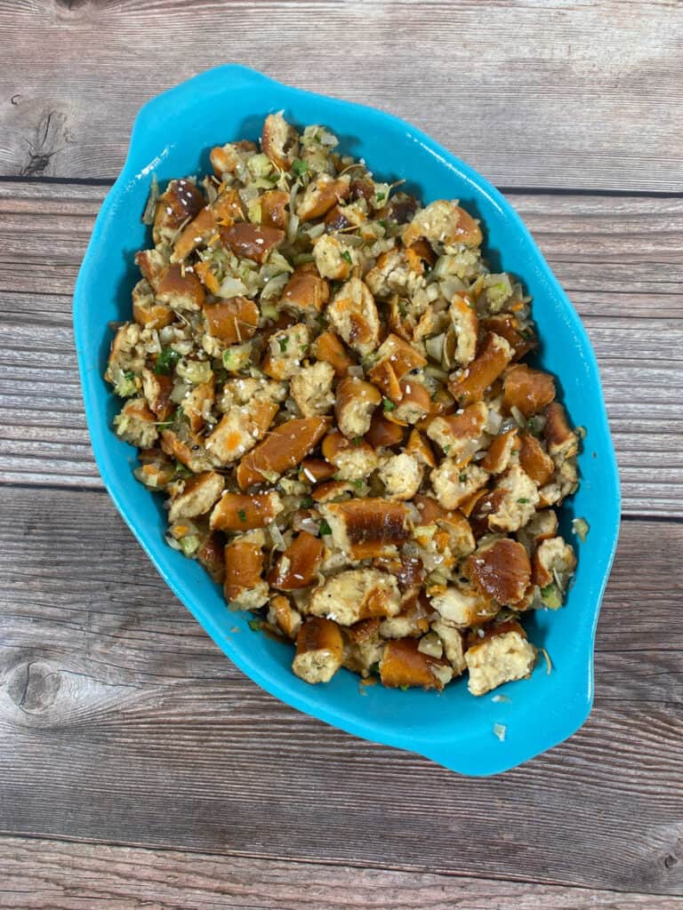 Process shot - mixed stuffing in blue casserole dish waiting to be baked. 