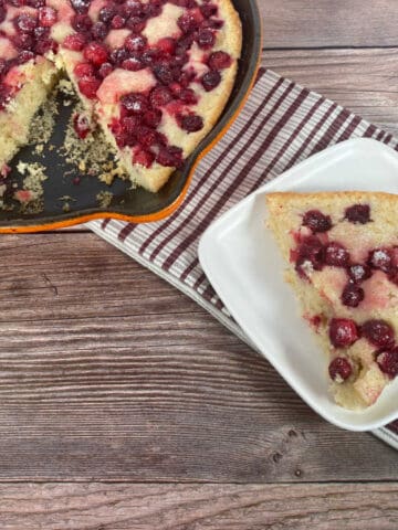 slice of cobbler sits on a white plate with dish next to it.