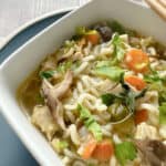 close up of soup in a square white bowl.