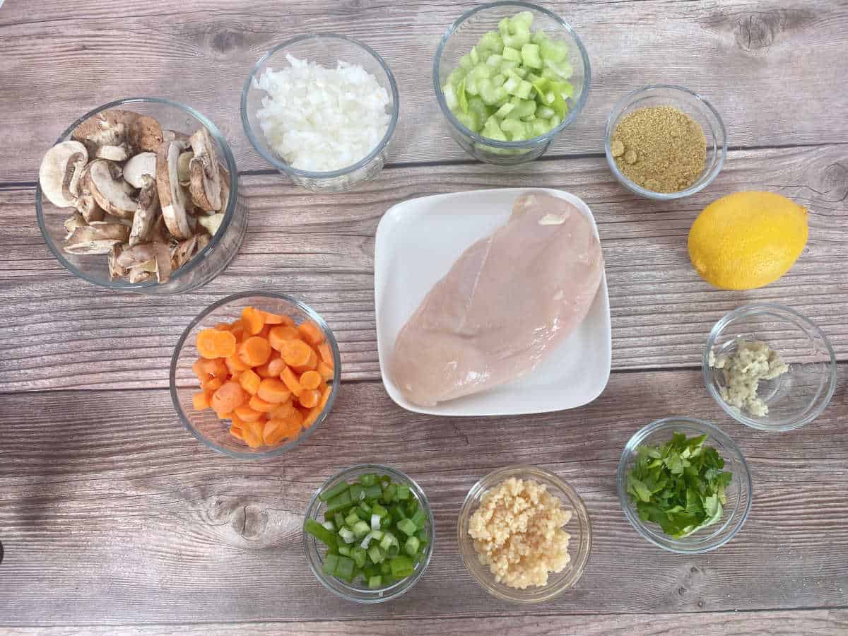 Ingredients for soup in glass bowls on a wooden background. 