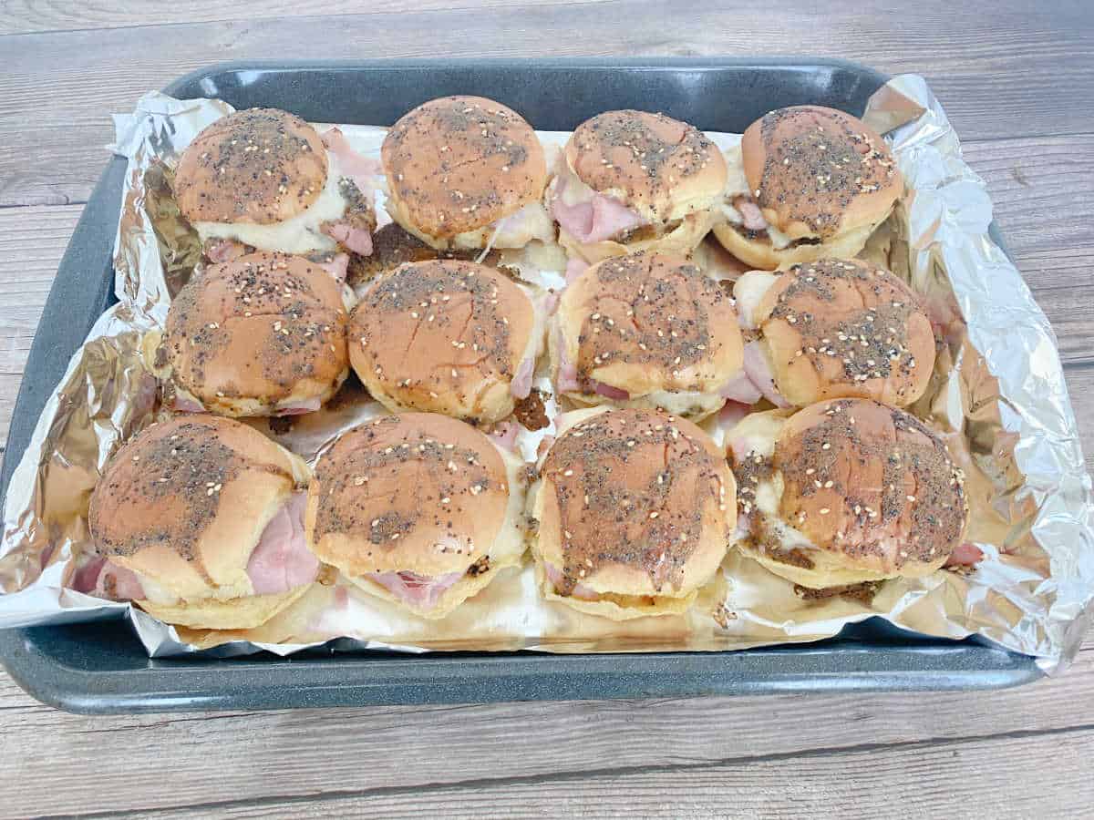 Baked sliders sit on a baking sheet. 