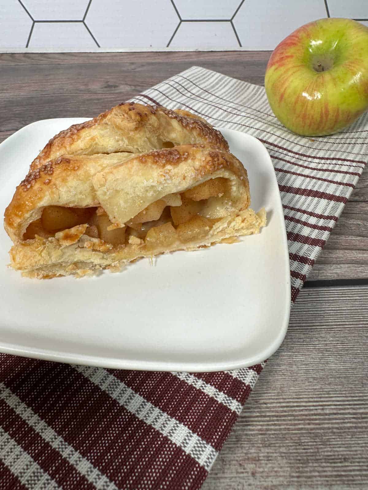 Close up image of slice of pastry with apples inside. 