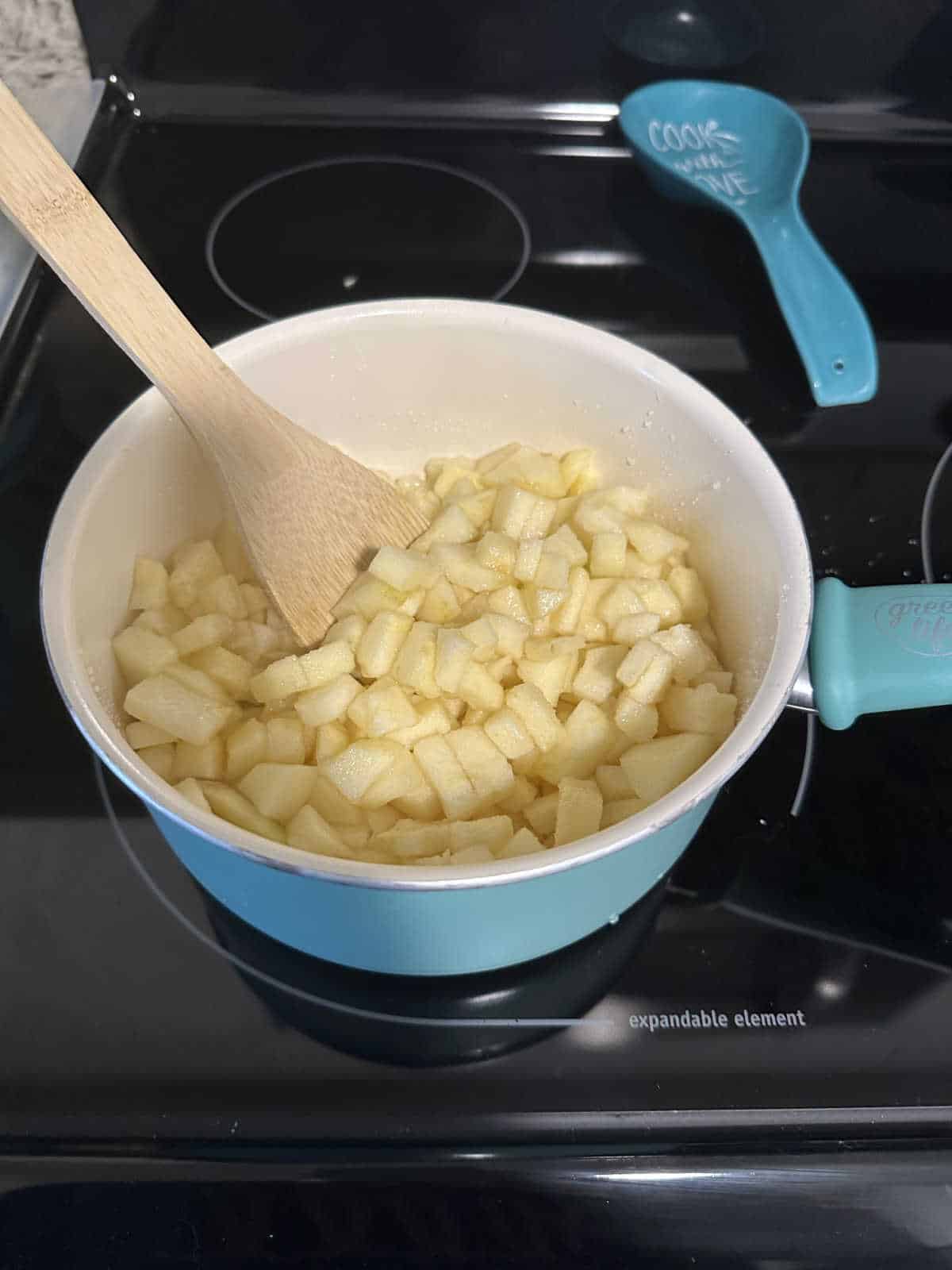 Process shot - apples and other ingredients in a saucepan.