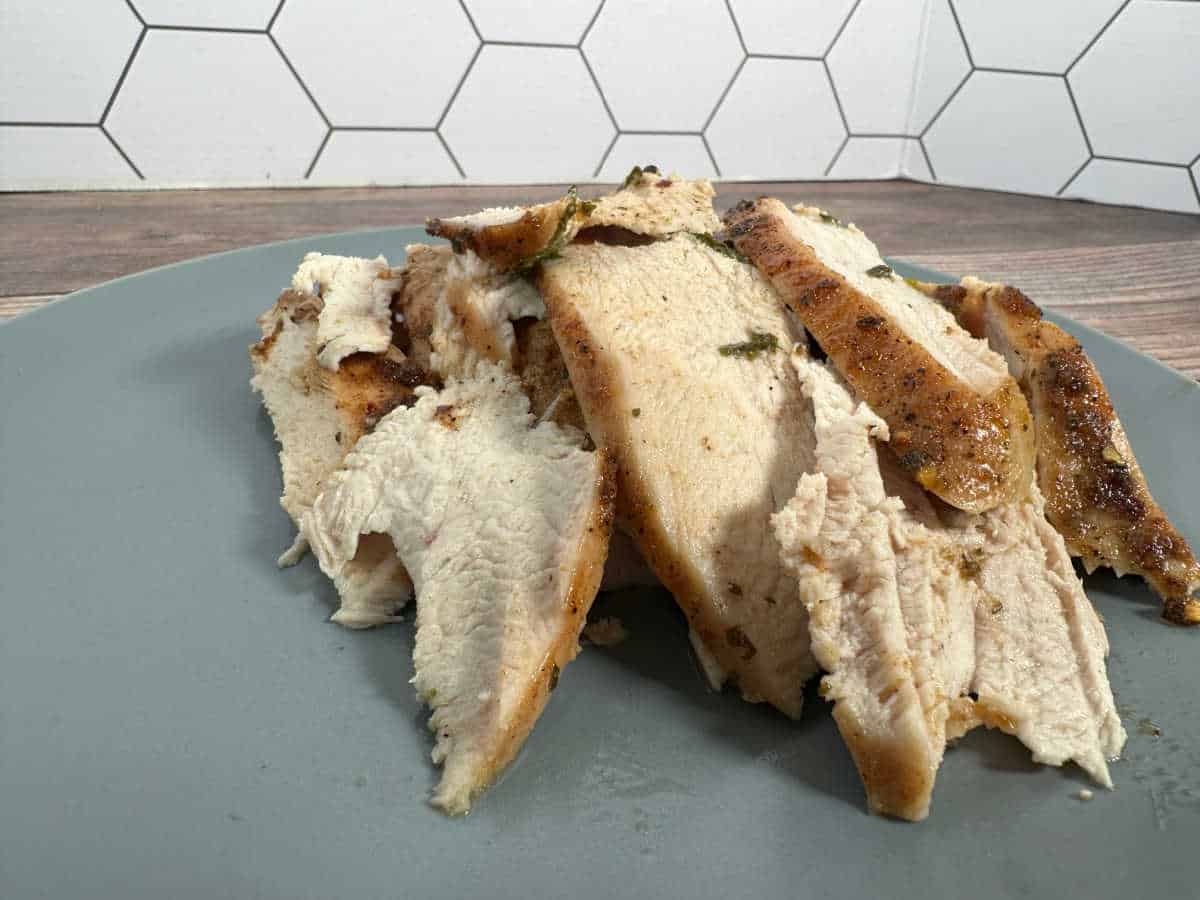 Slices of turkey breast sit on a light blue plate. 