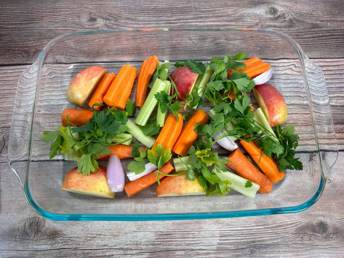 Process image - ingredients for the bed of vegetables sit in a 9x13 baking dish on a wooden background.