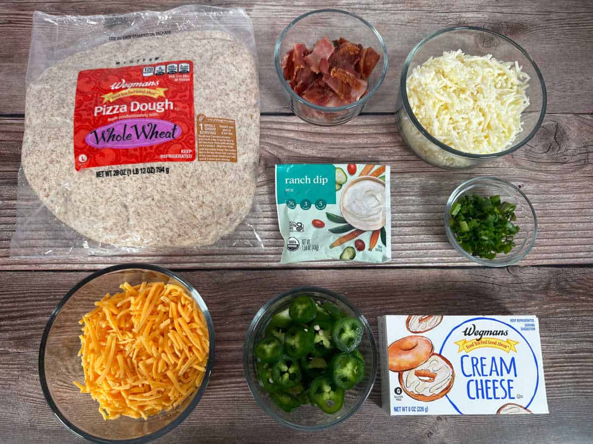 Ingredients for recipe sit in glass bowls on a wooden background. 