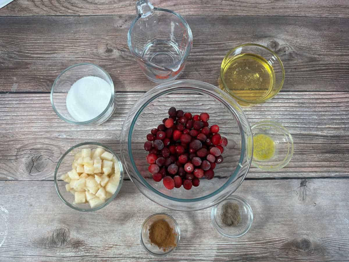 Ingredients for the recipe sit in glass bowls on a wooden background. 